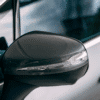 Close-up of Mercedes EQE SUV side mirror with protective film applied.